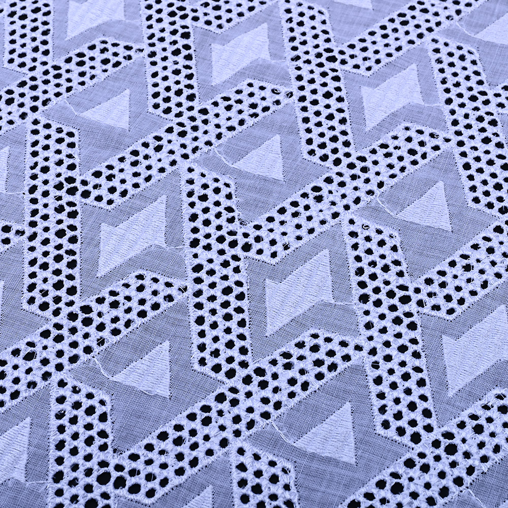 Geometric diamond eyelet pattern on white Swiss voile lace fabric