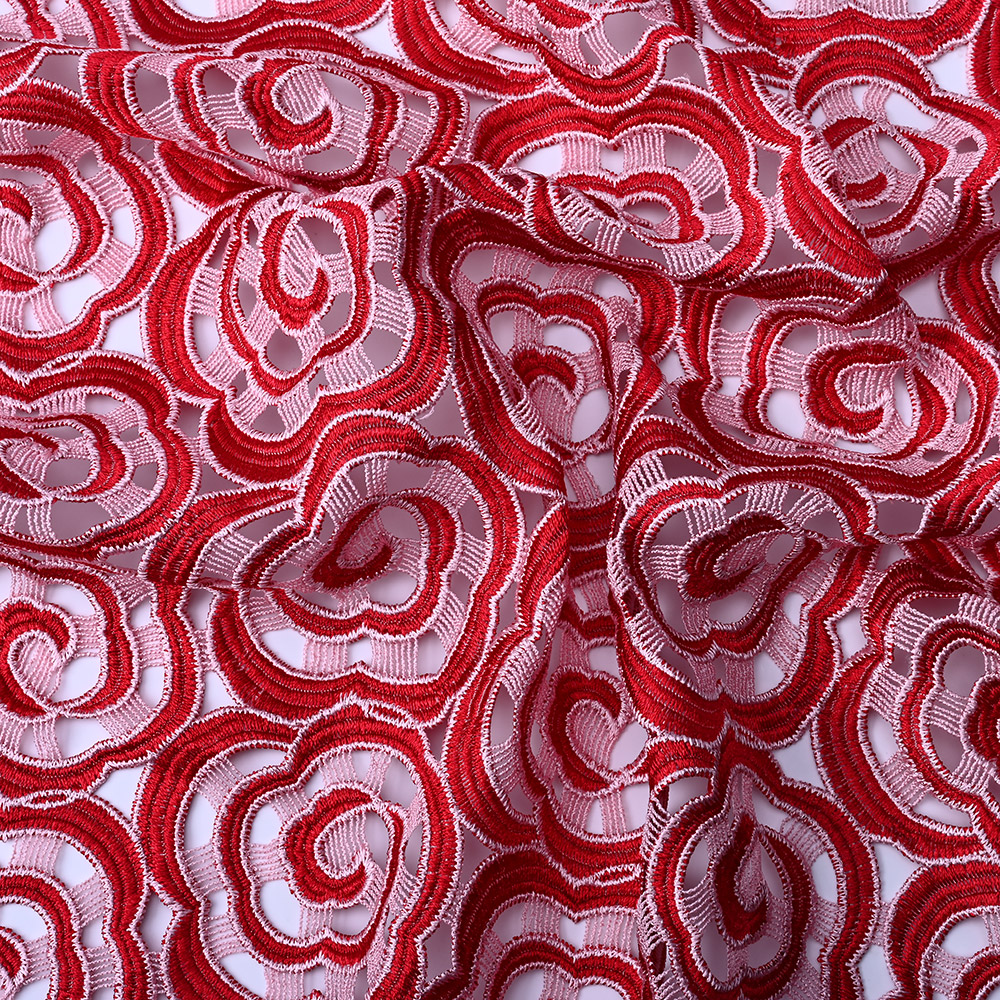 Red and pink spiral rose motifs on 3D guipure lace fabric